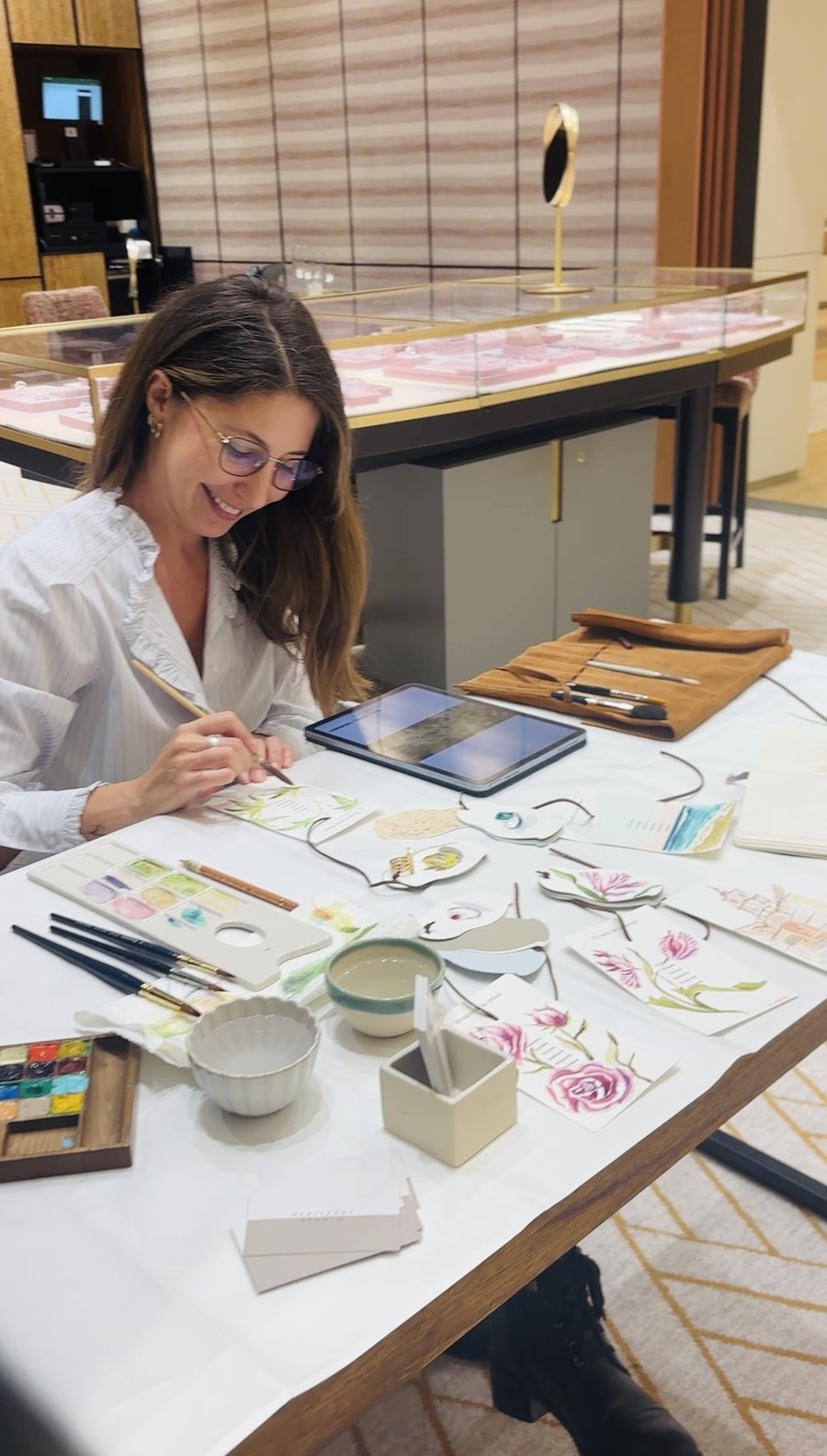 María Téllez pintando una tarjeta en acuarela durante el evento en tienda