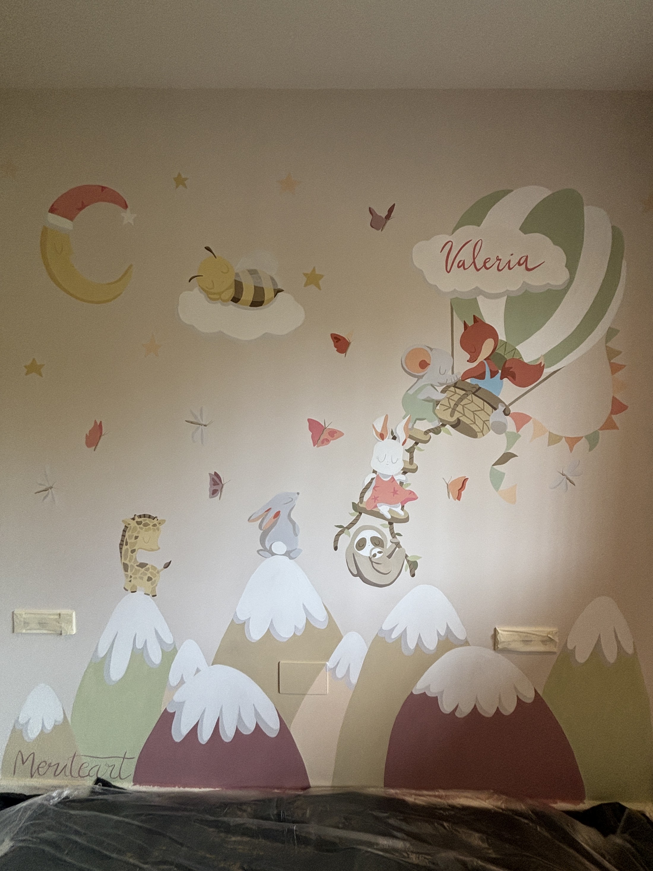 Mural infantil con un globo aerostático, montañas nevadas y animales en la habitación de una niña