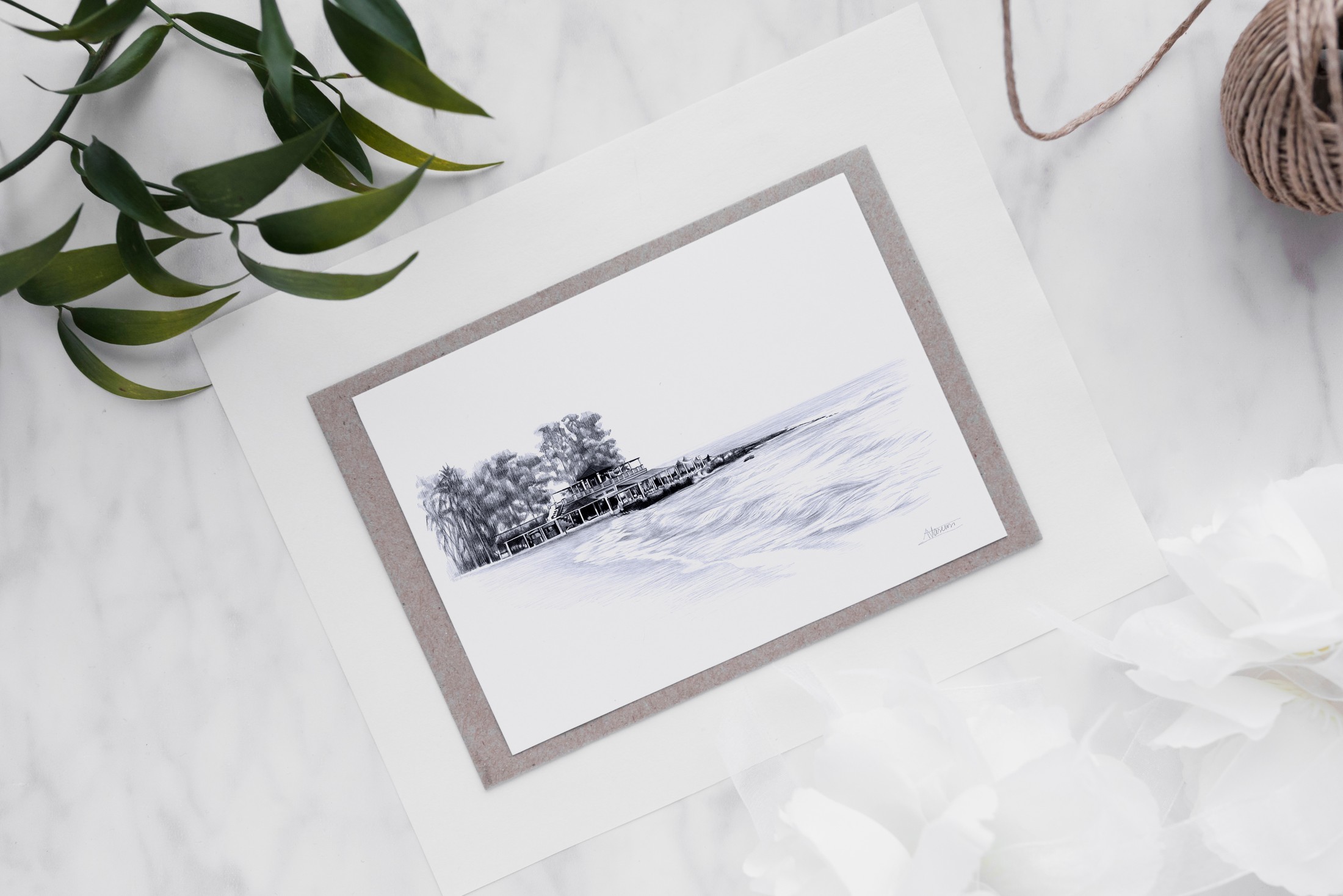 Recordatorio con un paisaje dibujado a tinta y enmarcado en papel gris