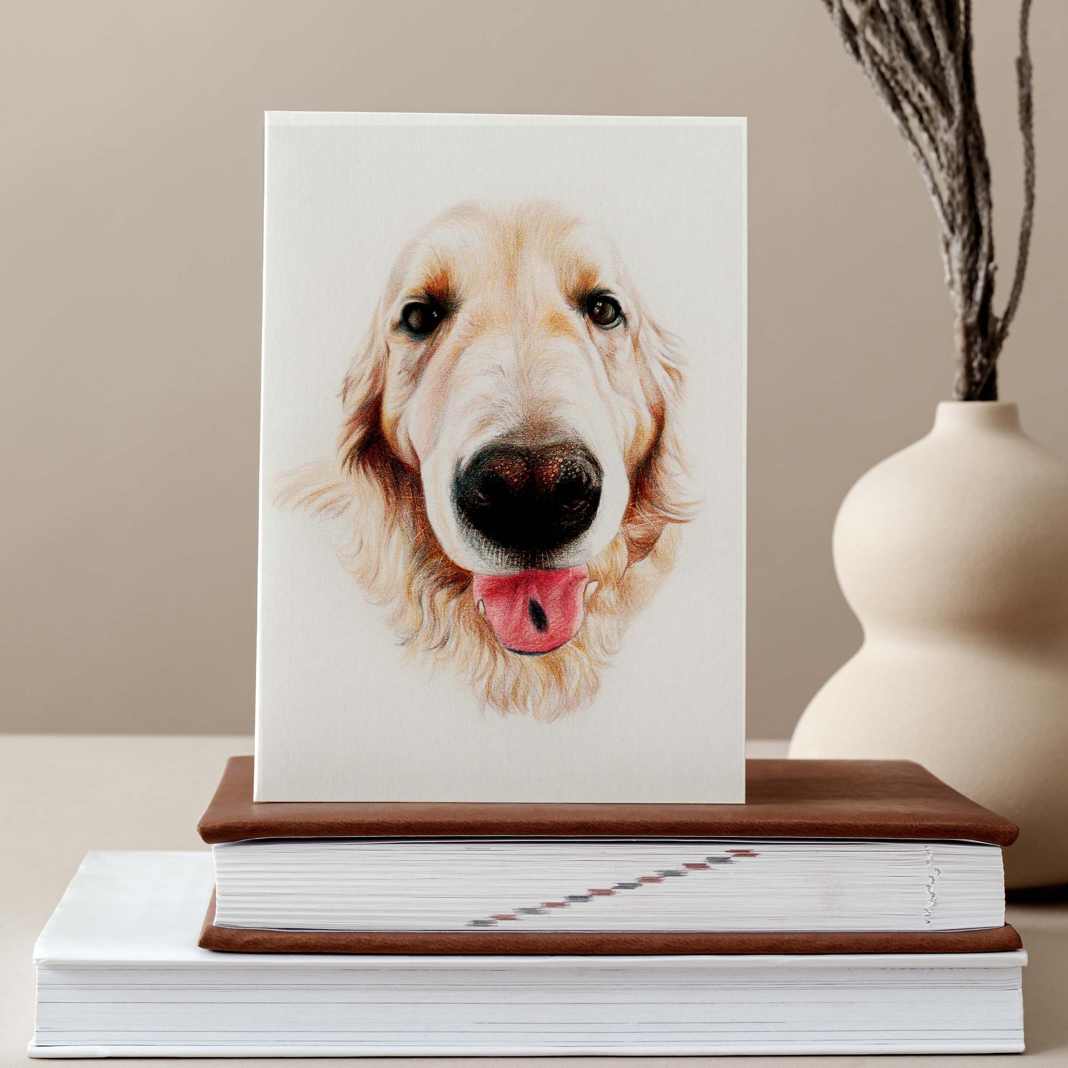 Retrato de un perro golden retriever con la lengua fuera, apoyado sobre una pila de libros